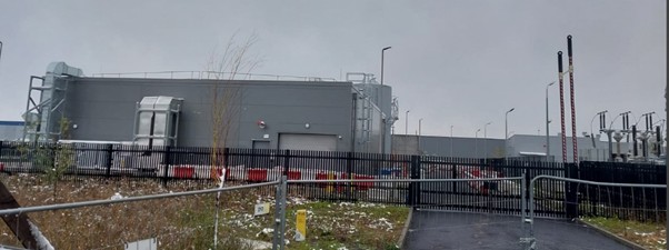 Ogrodzony teren z budynkiem w tle